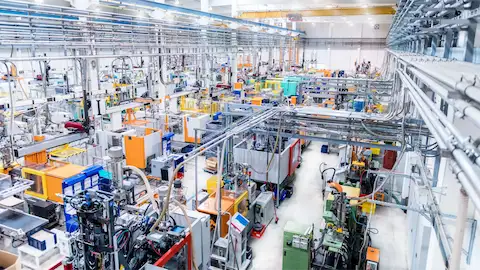 Uma visão aérea de uma fábrica moderna, repleta de máquinas e equipamentos.